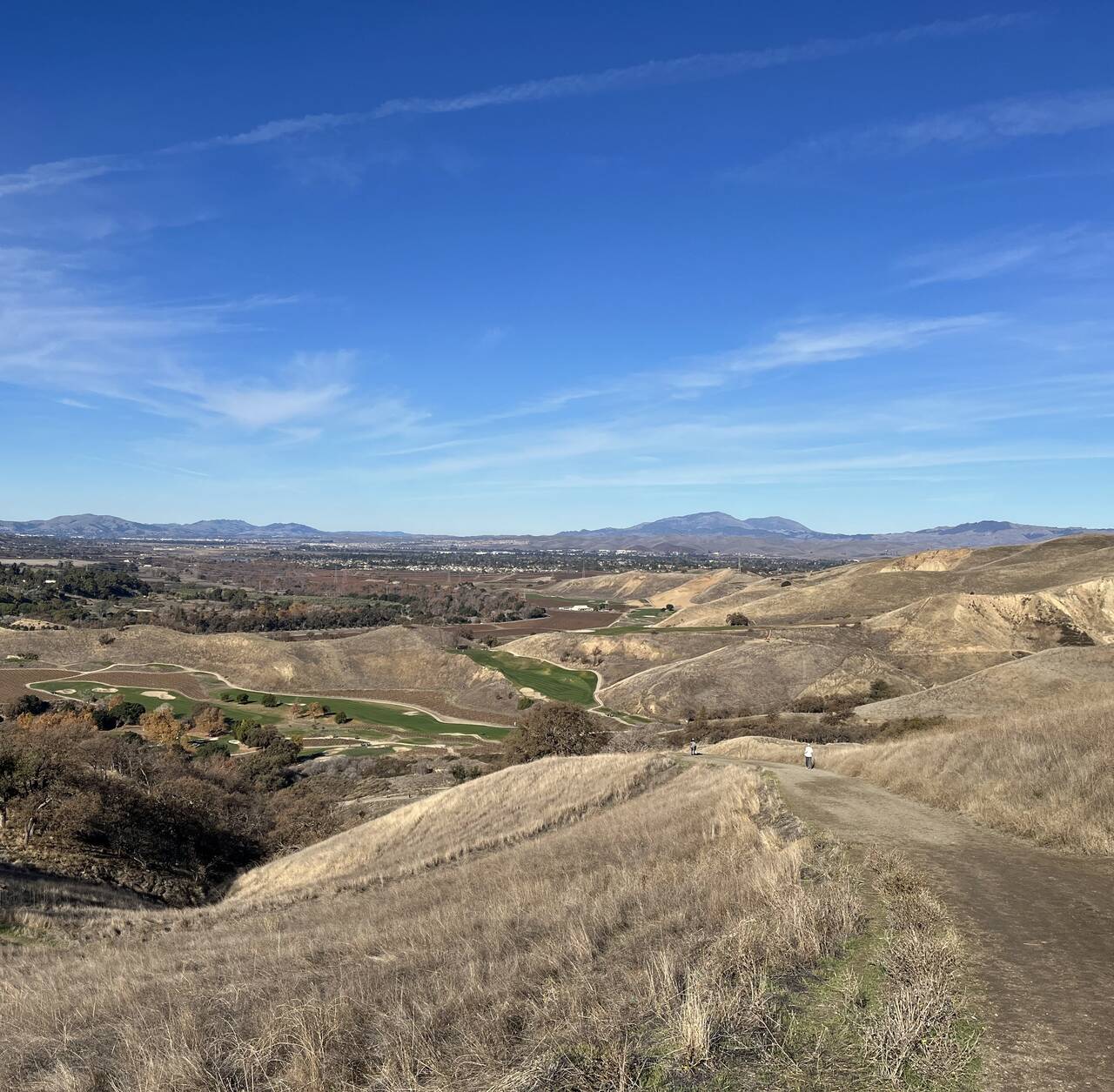 Looking back from the first hill near Del Valle, a green golf course stands out among the dry rolling hills