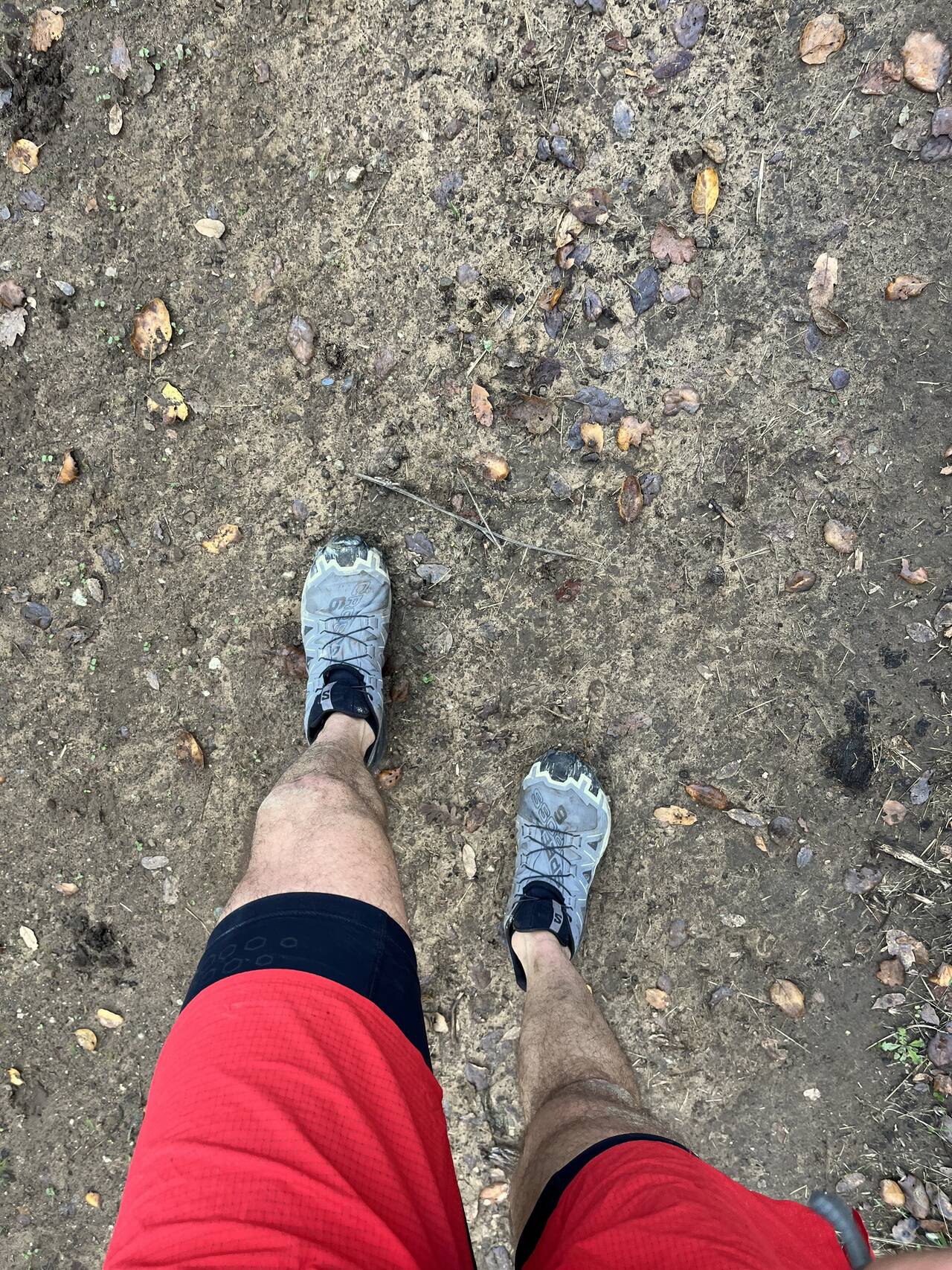 A standard downward-facing photo of legs and shoes on a dry path
