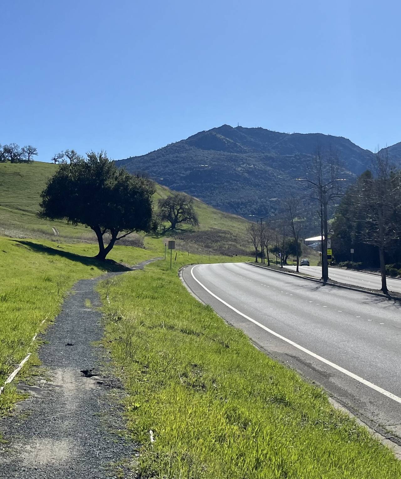 A highway extends toward Mount Diablo. A crushed gravel path lies off the side of the road.