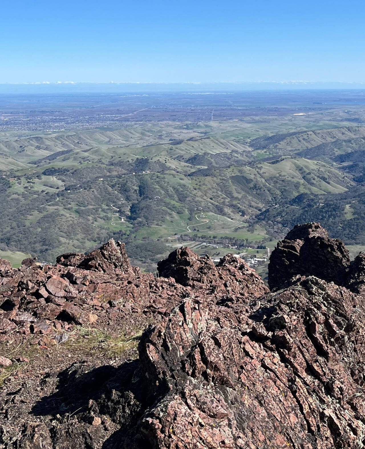 A near-birdseye view of the hills just run. A rocky outcropping sits in the foreground.